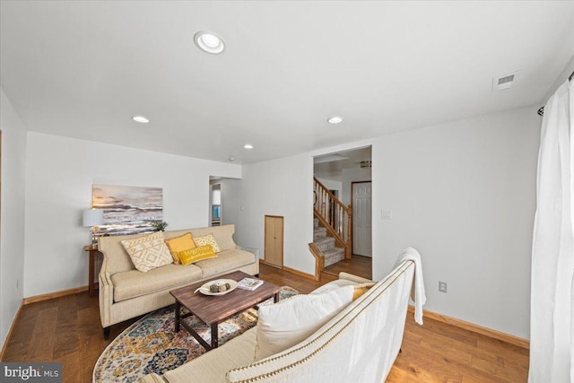 living room with stairs, visible vents, wood finished floors, and recessed lighting