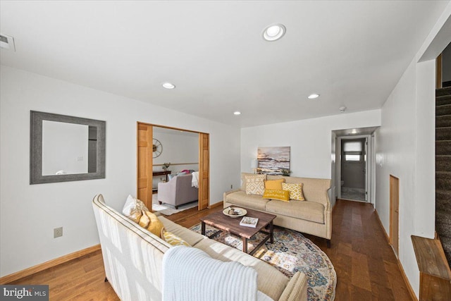 living area featuring baseboards, stairway, wood finished floors, and recessed lighting