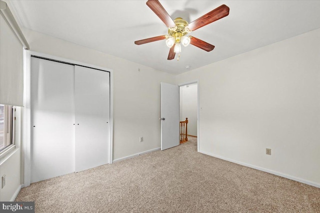 unfurnished bedroom with a closet, a ceiling fan, and carpet flooring