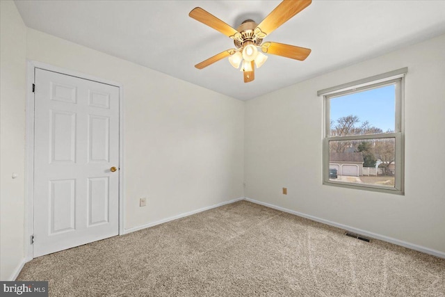 spare room featuring baseboards, visible vents, and carpet flooring