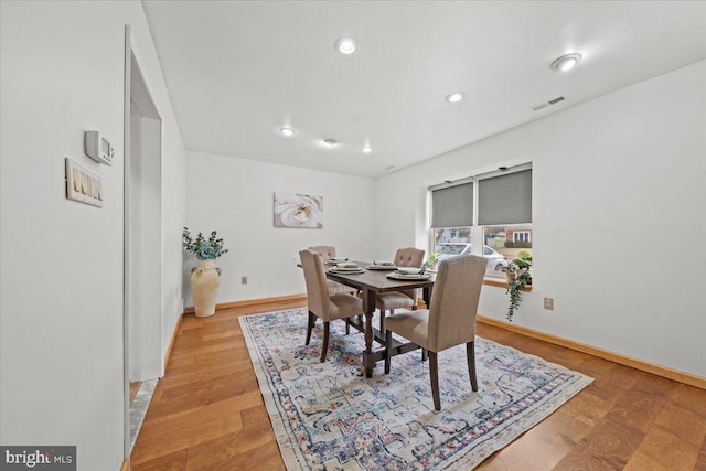 dining room featuring light wood finished floors, recessed lighting, visible vents, and baseboards