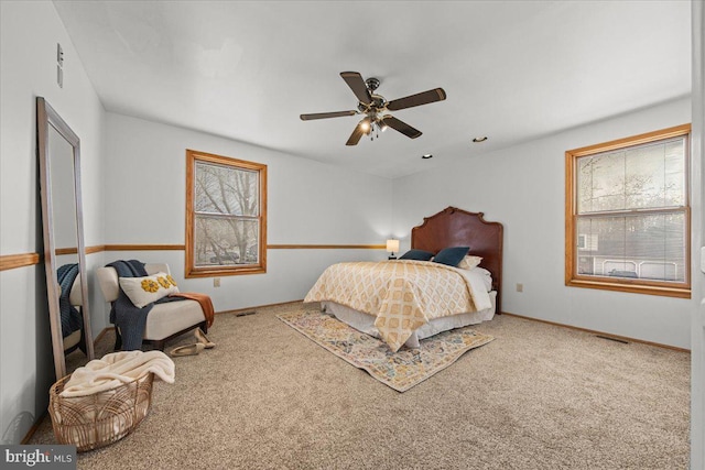 bedroom with carpet flooring, ceiling fan, visible vents, and baseboards