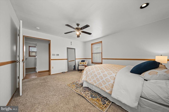 carpeted bedroom with multiple windows and ceiling fan