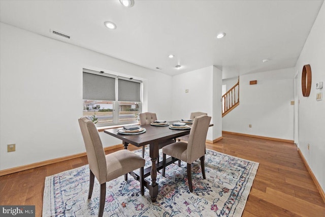 dining room with stairway, recessed lighting, wood finished floors, and baseboards