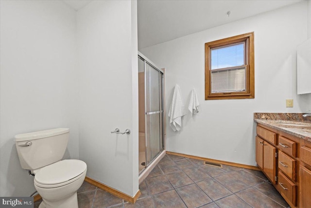 bathroom with toilet, a stall shower, baseboards, and vanity