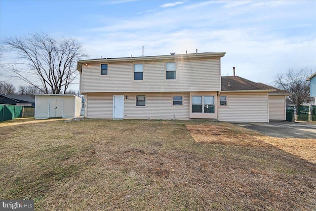 rear view of house featuring a storage shed, a yard, fence, and an outdoor structure