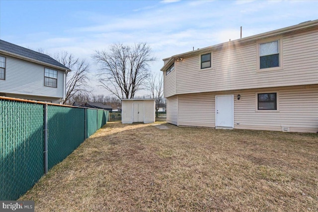 back of house with an outbuilding, a yard, a storage unit, and fence