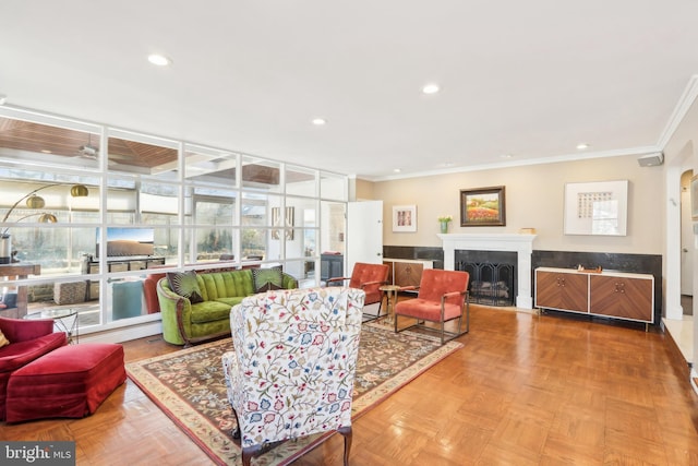 living room featuring crown molding, recessed lighting, and a fireplace