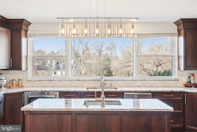 kitchen with light stone counters, a sink, dark brown cabinetry, decorative backsplash, and dishwasher