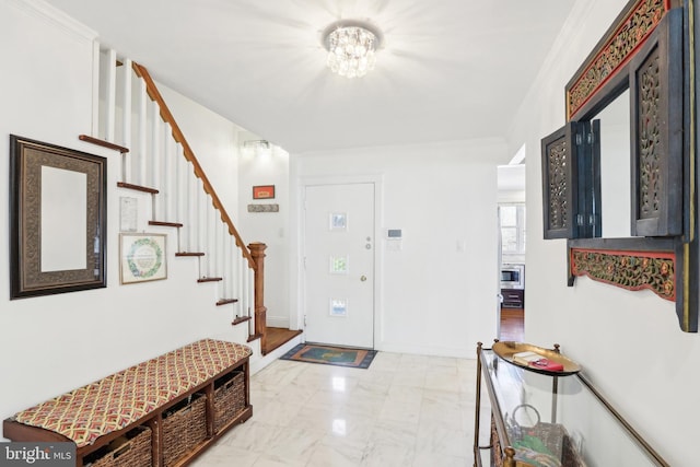 entrance foyer featuring stairway, baseboards, ornamental molding, a notable chandelier, and marble finish floor