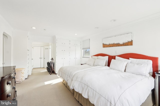 bedroom with recessed lighting, a closet, light carpet, and crown molding