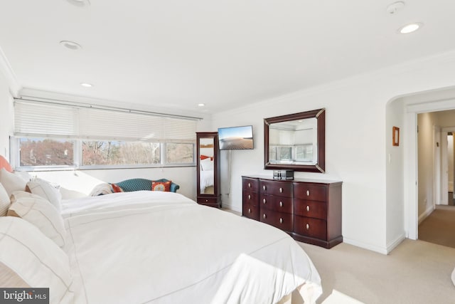 bedroom with ornamental molding, recessed lighting, arched walkways, baseboards, and light colored carpet