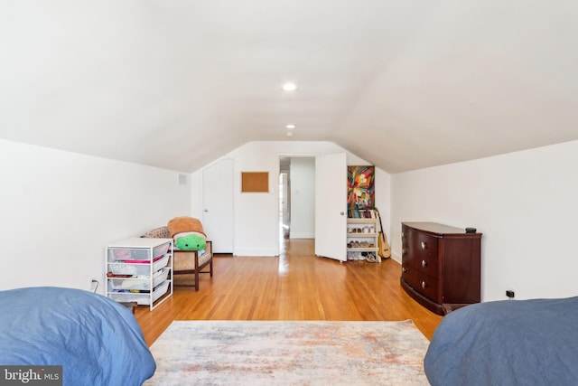 bedroom with lofted ceiling and wood finished floors