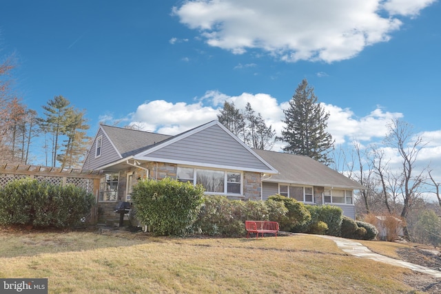 view of front facade featuring a front yard and stone siding