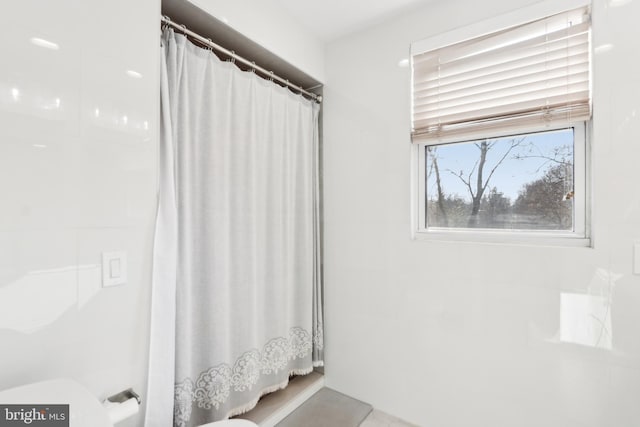 bathroom with a shower with curtain and toilet