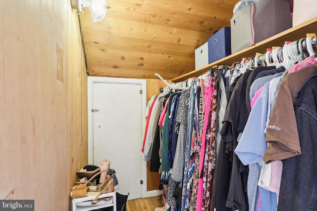 walk in closet with lofted ceiling and wood finished floors