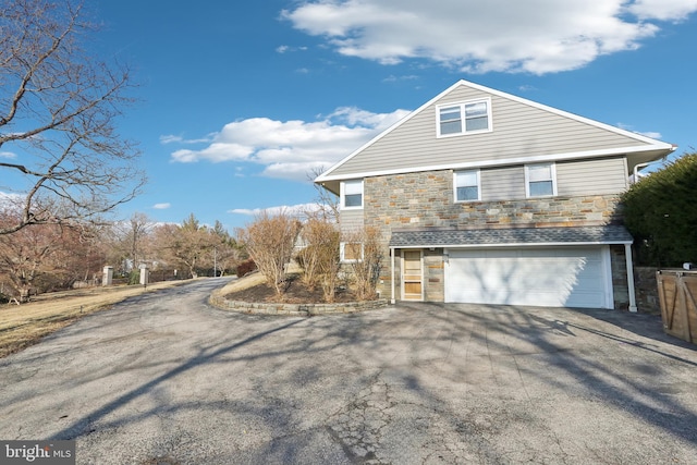 view of home's exterior featuring aphalt driveway, an attached garage, and stone siding