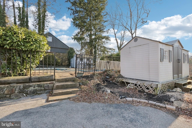 view of yard featuring an outbuilding, a shed, and fence