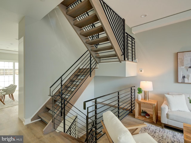 staircase featuring baseboards and wood finished floors