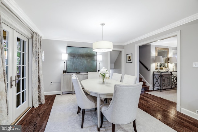 dining room featuring stairway, wood finished floors, baseboards, and ornamental molding