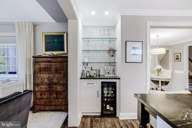 bar with beverage cooler, recessed lighting, ornamental molding, a bar, and dark wood-type flooring