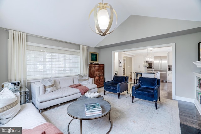 living area with a chandelier, high vaulted ceiling, baseboards, and wood finished floors