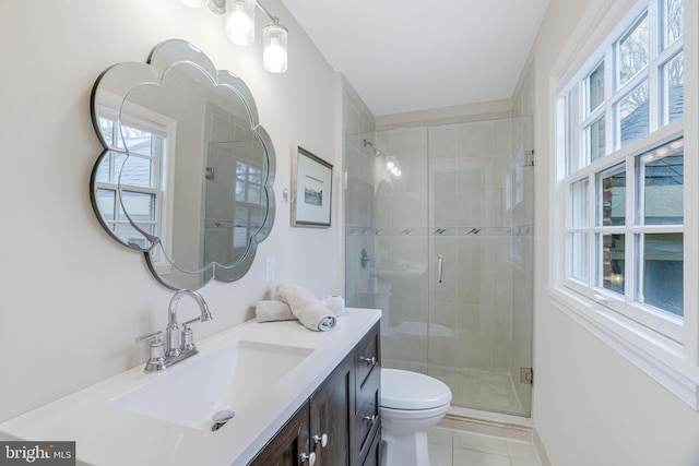 bathroom with vanity, toilet, a stall shower, and tile patterned flooring