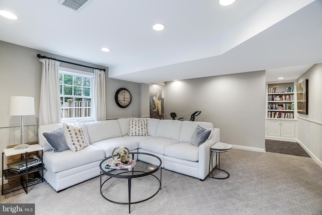 living room featuring built in shelves, visible vents, baseboards, recessed lighting, and carpet flooring