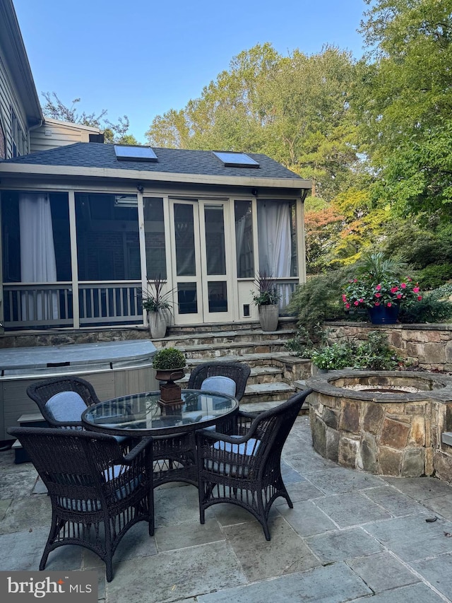 view of patio with outdoor dining area and a sunroom