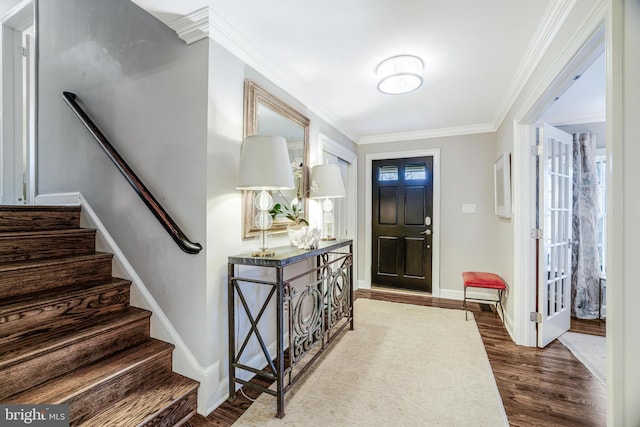 foyer with crown molding, stairs, dark wood-type flooring, and baseboards