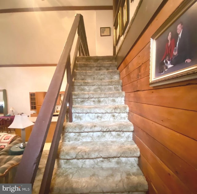 staircase featuring wood walls