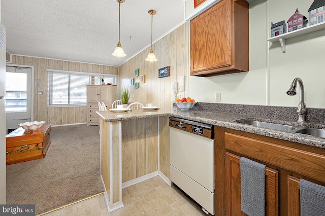 kitchen featuring light carpet, dishwasher, brown cabinets, a peninsula, and a sink