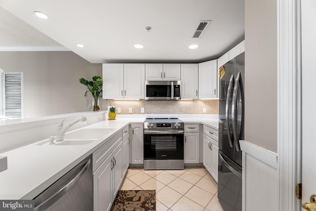 kitchen featuring light tile patterned floors, visible vents, appliances with stainless steel finishes, white cabinetry, and a sink