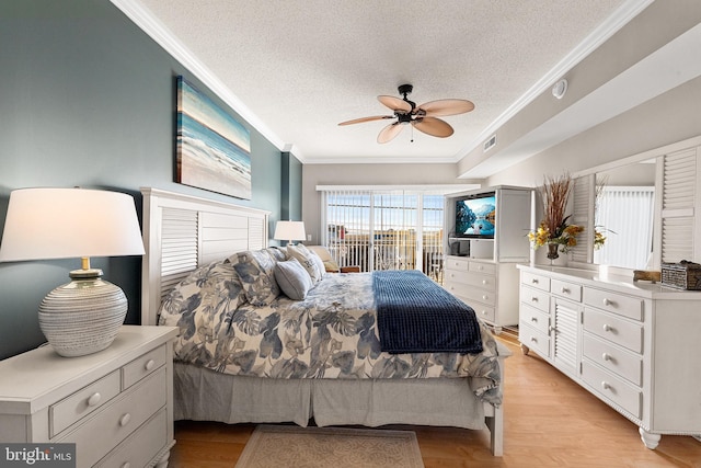 bedroom with light wood-style floors, a textured ceiling, visible vents, and crown molding