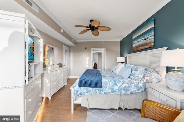 bedroom featuring crown molding, visible vents, light wood-style flooring, a ceiling fan, and baseboards