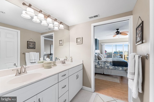 full bath featuring connected bathroom, visible vents, a sink, and double vanity