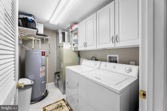 laundry room featuring cabinet space, baseboards, washer and clothes dryer, water heater, and light tile patterned flooring