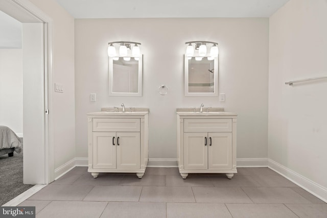 full bathroom featuring two vanities, a sink, tile patterned flooring, and baseboards