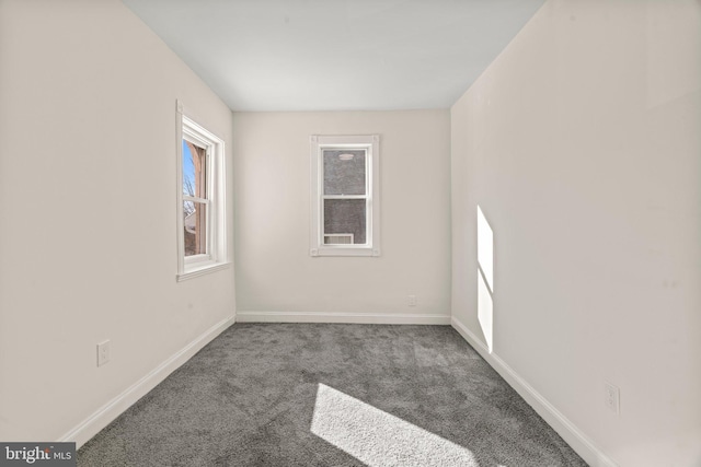 carpeted empty room featuring baseboards