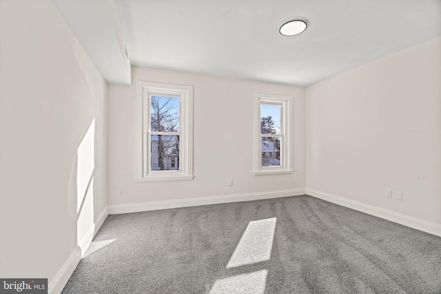 unfurnished room with carpet and baseboards