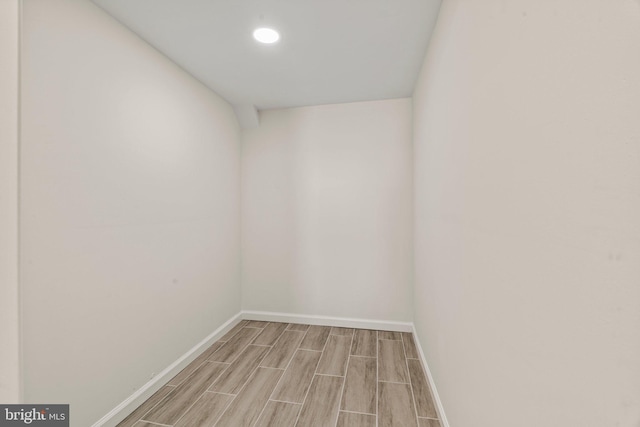 empty room featuring wood finish floors, recessed lighting, and baseboards