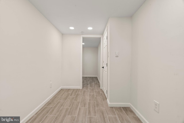 hall featuring wood tiled floor, baseboards, and recessed lighting