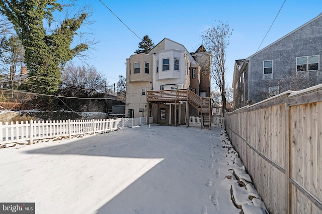 back of house featuring stairway and fence