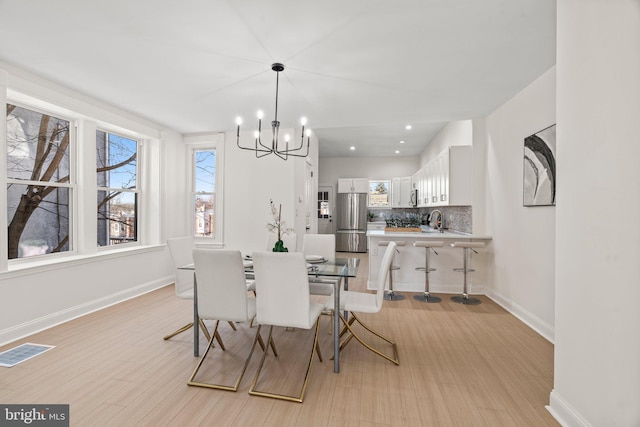 dining room with recessed lighting, visible vents, light wood-style flooring, an inviting chandelier, and baseboards