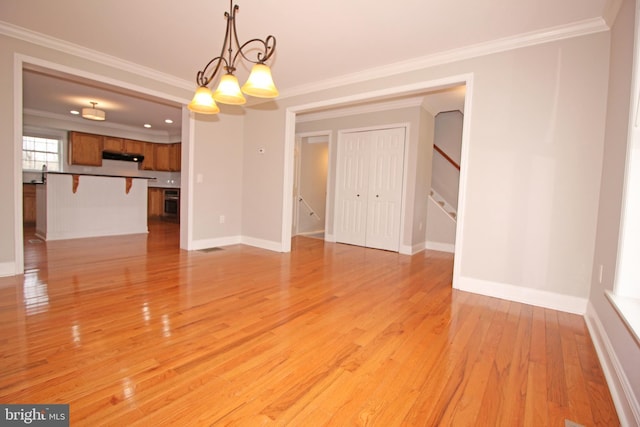 interior space with crown molding, stairway, light wood-style flooring, a chandelier, and baseboards