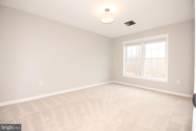 spare room with baseboards, visible vents, and carpet flooring