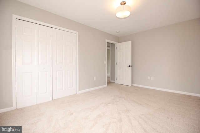 unfurnished bedroom with carpet, baseboards, and a closet