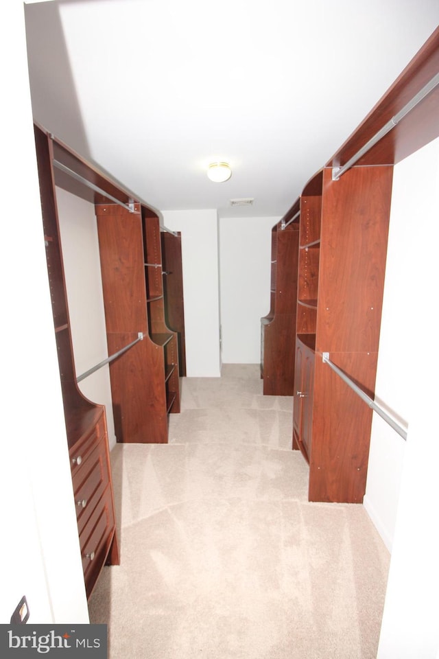 walk in closet featuring visible vents and light colored carpet