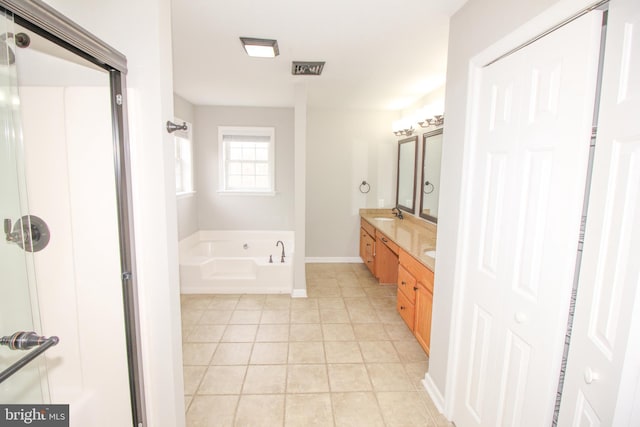 bathroom featuring double vanity, a sink, tile patterned flooring, baseboards, and a bath