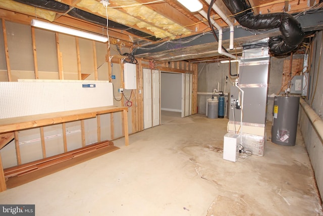 unfinished below grade area with electric panel, water heater, and a workshop area